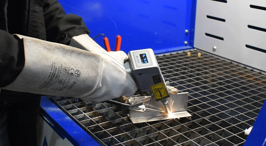 Torche de soudage qui soude une pièce sur une table aspirante