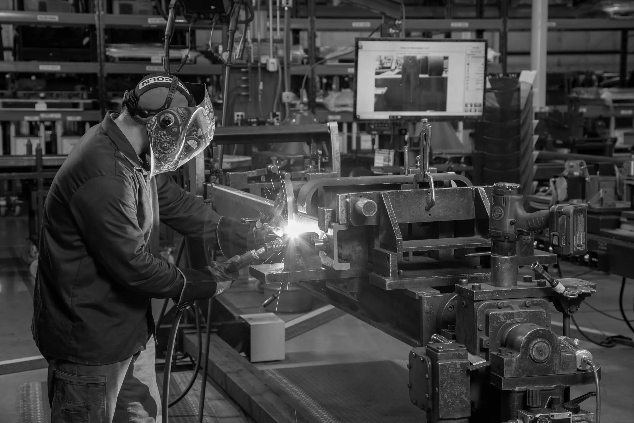 Soudeur réalisant une opération de soudage dans un atelier industriel.